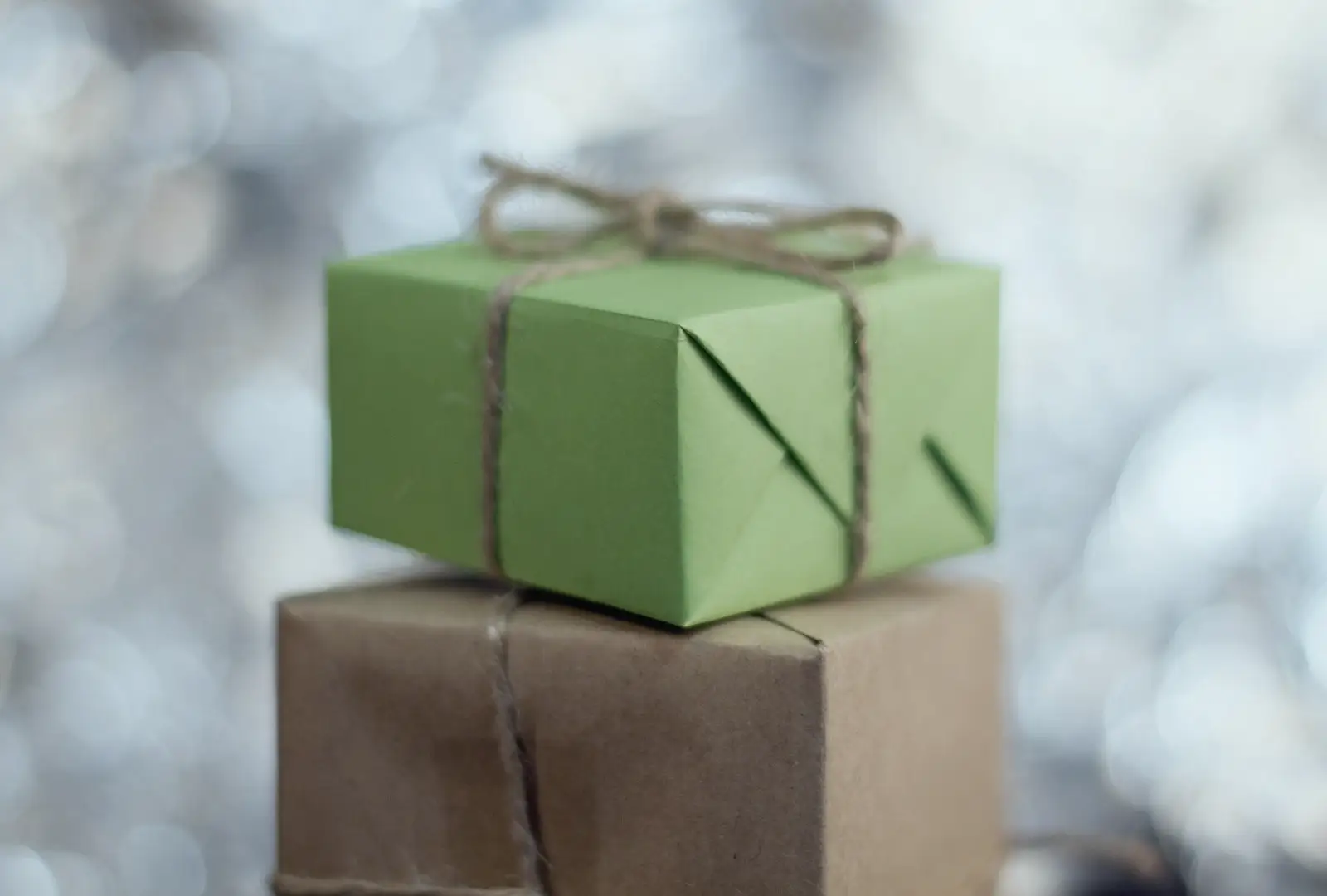 Un cadeau emballé de papier vert et noué de ficelle