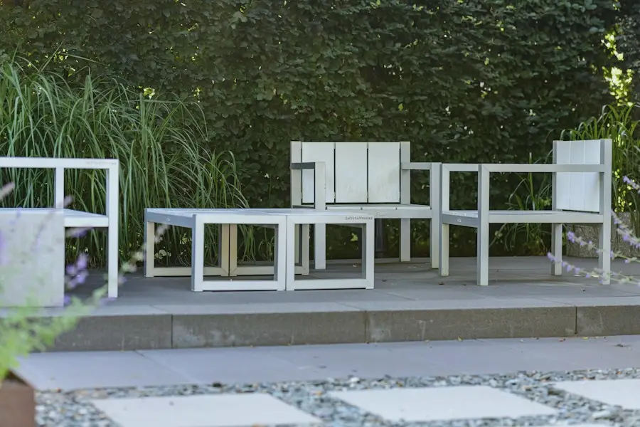 Une terrasse contemporaine réalisée, mobilier blanc, dallage et graminées